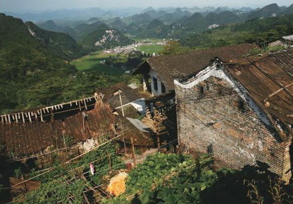 油岭瑶寨许多传统建筑已无人居住。不远的山下就是移民新村。