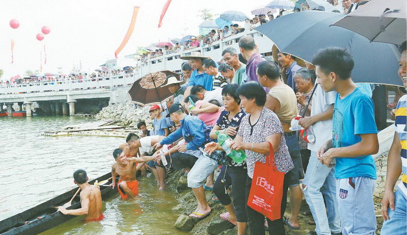 围观的人群拿着瓶子向冠军讨“龙汁”。龙汁即是龙船在比赛时溅在龙舟上的水,喝了龙汁有带来吉祥之意。
