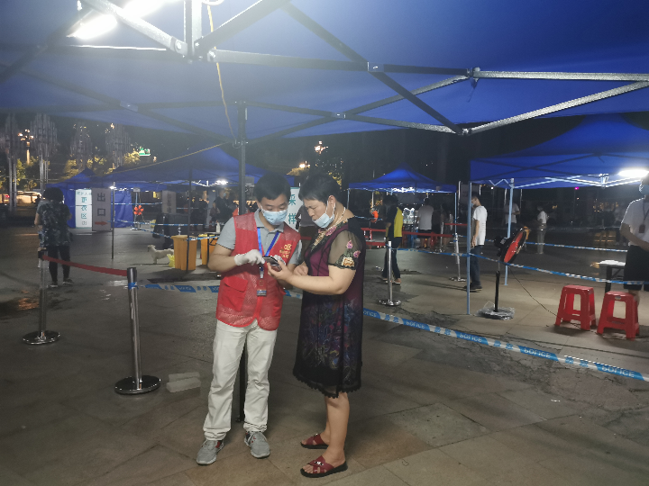 2021年6月9日，清远市水利局第三批党员突击队志愿者主动亮身份，指引群众使用“粤核酸”小程序登记收件人员信息，并耐心解释核酸检测注意事项。.jpg