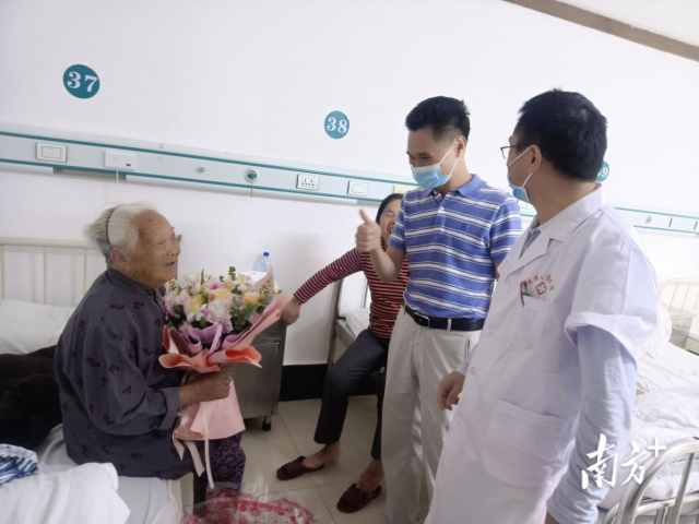 清远市退役军人事务局党组成员陈应良在询问医生，了解老人的康复情况，并祝福老人早日健康出院。